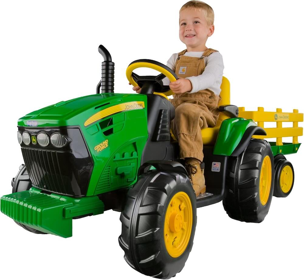 Picture of a kid on a Peg Perego John Deere Ground Force Tractor with Trailer 12 Volt Ride on
