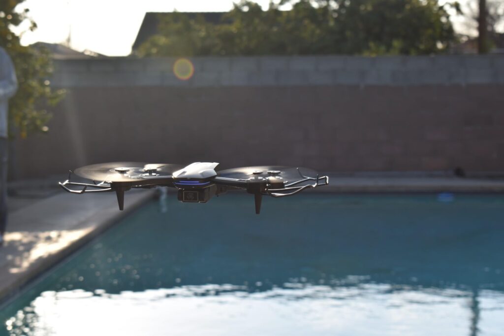 flight performance and range of the drone shown flying above a pool in a backyard