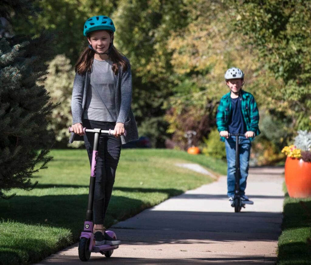Kids riding a scooter on the sidewalks