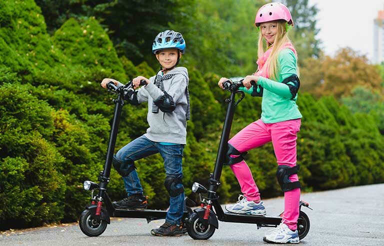 Two kids riding their new electric scooters